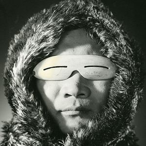 An Inuit man wearing effective snow goggles carved from bone. The long, narrow slits allow for good vision but block much UV light reflecting off snow.