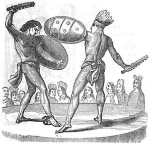 One man is chained to the ground by his ankle, blocking a weapon with his shield in his left hand and raising a club in the other. A Maya man in a headdress swings a weapon in his right hand and has his shield raised in defense in the other. Both men are being watched by a crowd in the background.