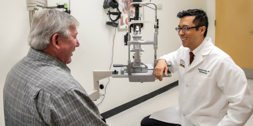 El Dr. Augustine Hong le practica un examen oftalmológico a su paciente, Bobby Moyers.