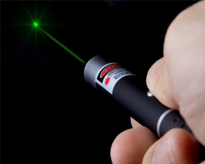A laser pointer shines green light into the distance.