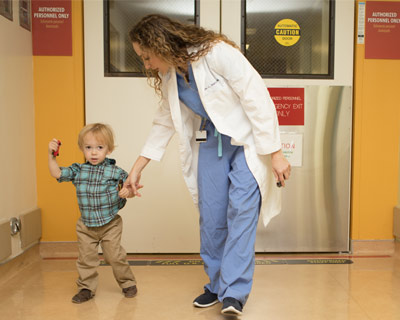 Jesse Berry, MD and Cooper, in a hospital hallway at a door.