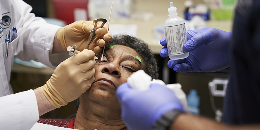 Un oftalmólogo inyecta el ojo de una mujer con degeneración macular.