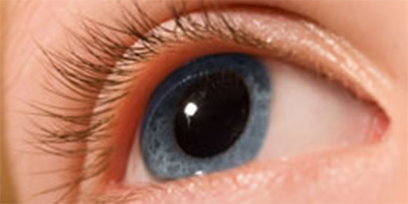 Imagen de primer plano de un ojo azul con pupila dilatada