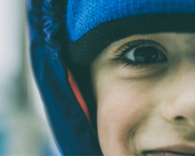 Portrait of child with dark brown eyes in winter hat