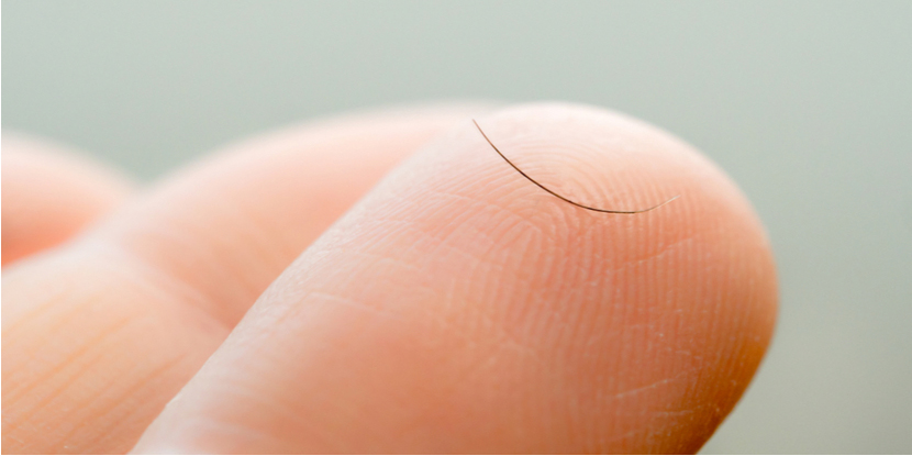 Close up of an eyelash on a person's fingertip