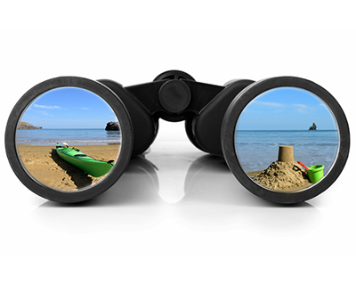 A pair of binoculars looking at a beach scene