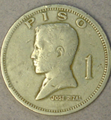A small silver-colored coin with a man's face in profile on it. The man's face looks towards the left. The text across the top edge of the coin reads: PISO. The text across the bottom edge of the coin reads: Jose Rizal 1.