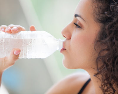 Photograph of a woman drinking from a water bottle