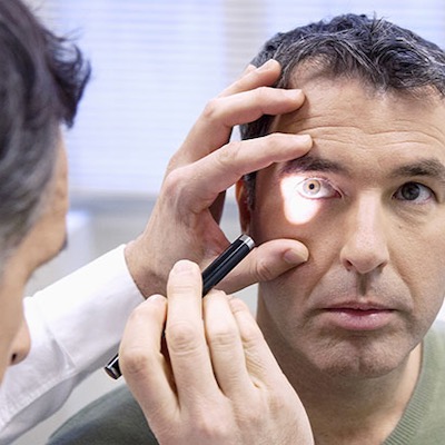 An ophthalmologist gives an eye exam to a military veteran.