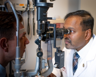 Seenu M. Hariprasad, MD, examines a patient's eyes