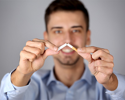 Photograph of a man breaking a cigarette