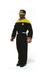 A large action figure of a Black man in a black and yellow Star Trek uniform. The figure is about six inches tall. The man is young with dark skin and wears a gold and silver visor across his eyes. The action figure is being held up at the waist by a white wire stand.