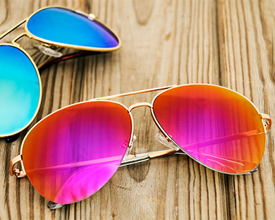 Two pairs of sunglasses with brightly-tinted lenses