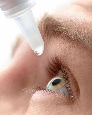 Close up photograph of a person putting in eye drops