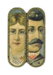 An advertisement brochure in the shape of an eyeglass case. The brochure has an image of a woman on one side and a man on the other. The woman is white with blonde hair and wears a lace collar. She is also wearing gold-framed eyeglass lenses clipped to the bridge of her nose. The man is white with black hair and a black mustache and he is wearing a suit. He is also wearing gold-framed eyeglass lenses clipped to the bridge of his nose. The brochure has a black border around it with small gold text.