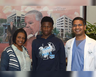 Javonte McNair with mother and Ajay Kuriyan MD after recovery from fireworks injury