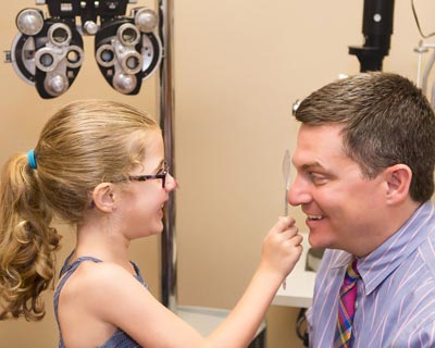 Callie, que quiere llegar a ser algún día doctora, con su oftalmólogo, el Dr. Aaron M. Miller