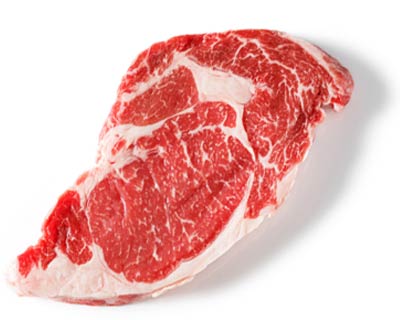 A raw boneless rib eye steak on a white surface.