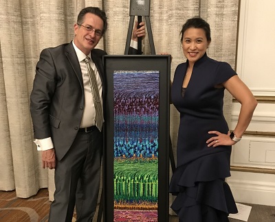 Janice Law and Adam Reynolds with his cross-sectional painting of the human retina.