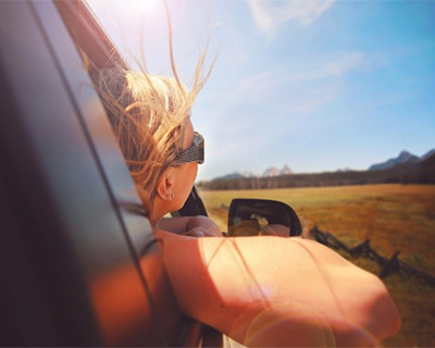 Photograph of a person with their head out a car window
