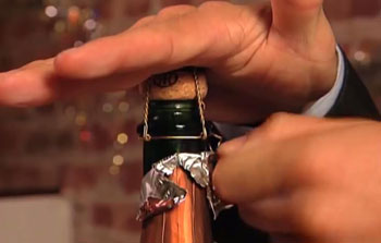 Hand covering a Champagne bottle cork