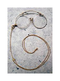 A pair of circular eyeglass lenses connected together. There is a long wire hoop connected to one lens intended to be worn over an ear.