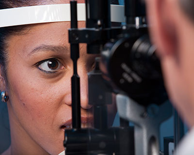El oftalmólogo usa un microscopio con lámpara de hendidura para examinar los ojos de la mujer