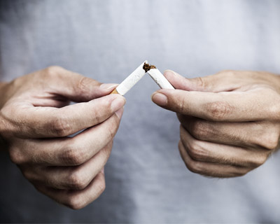 Photograph of a man breaking a cigarette