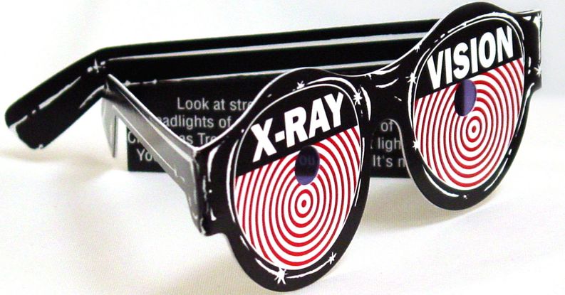 A pair of paper novelty eyeglasses. The glasses are black and the lenses have red and white circles radiating out from their center. There is a small hole in the lenses and the top of each lens reads XRAY VISION.