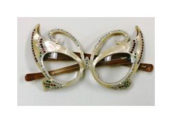 A pair of novelty eyeglasses with large, detailed cat-eye frames. The frames are white plastic with many small plastic jewels on them. Their cat-eye shape is so exaggerated they almost appear like a butterfly.